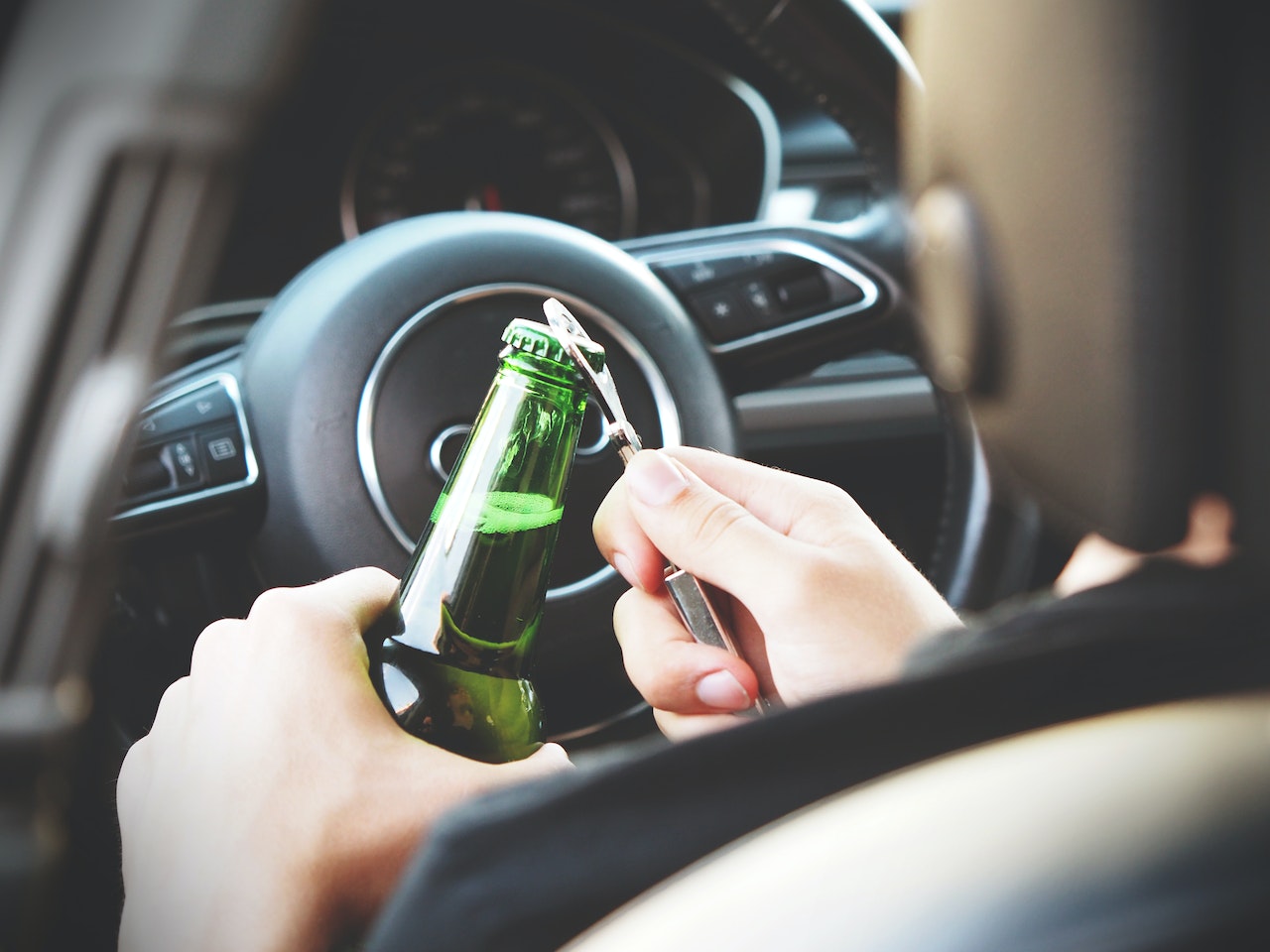 homem abrindo cerveja ao volante.jpg